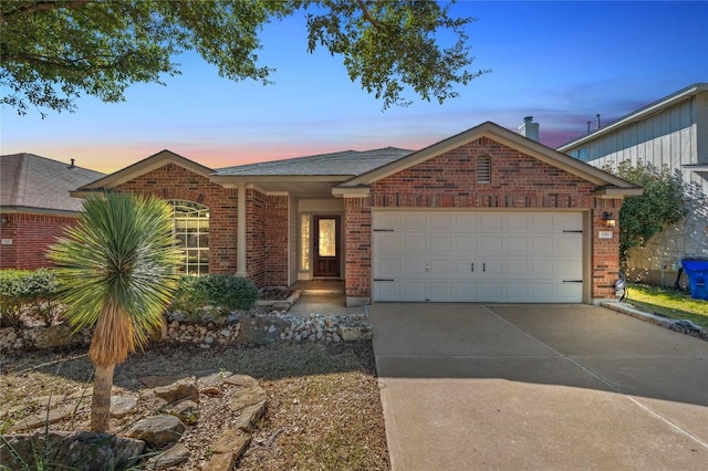 ranch-style home featuring brick siding, driveway, and an attached garage