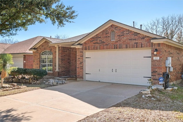 single story home featuring concrete driveway, brick siding, and an attached garage