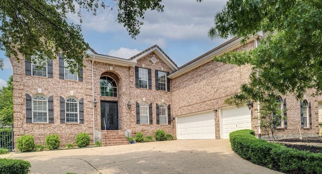 view of front facade featuring driveway, an attached garage, and brick siding