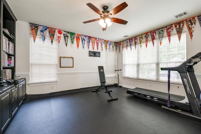 workout area with baseboards, visible vents, and a ceiling fan