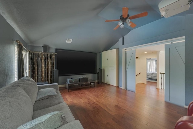 living room featuring a ceiling fan, visible vents, vaulted ceiling, and wood finished floors