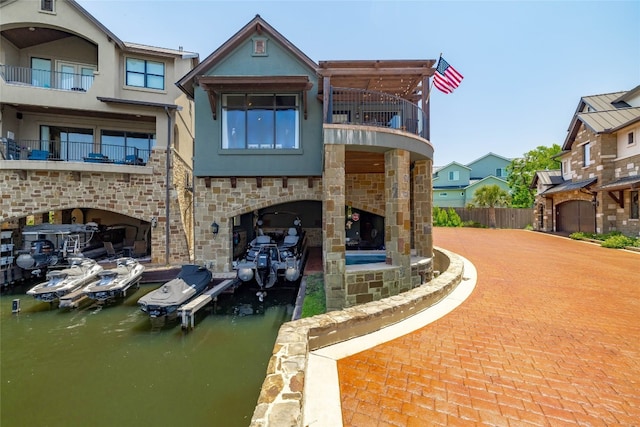 211 Chandler Way, Kingsland, TX 78639 - rear view of house with a balcony, stone siding, stucco siding, and a water view