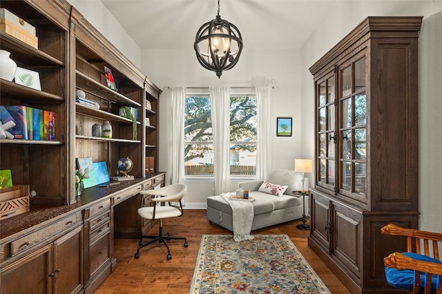 office with an inviting chandelier, dark wood finished floors, and built in study area