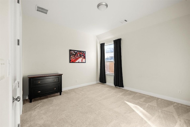 unfurnished room with visible vents, light carpet, and baseboards