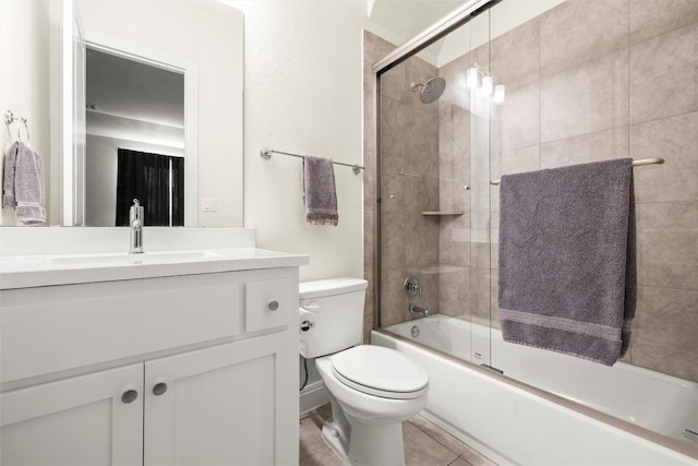 bathroom featuring tile patterned flooring, enclosed tub / shower combo, vanity, and toilet