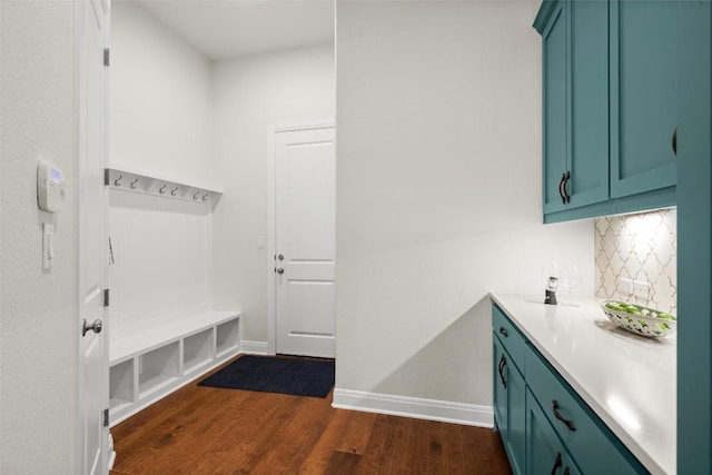 mudroom with dark wood-style floors and baseboards