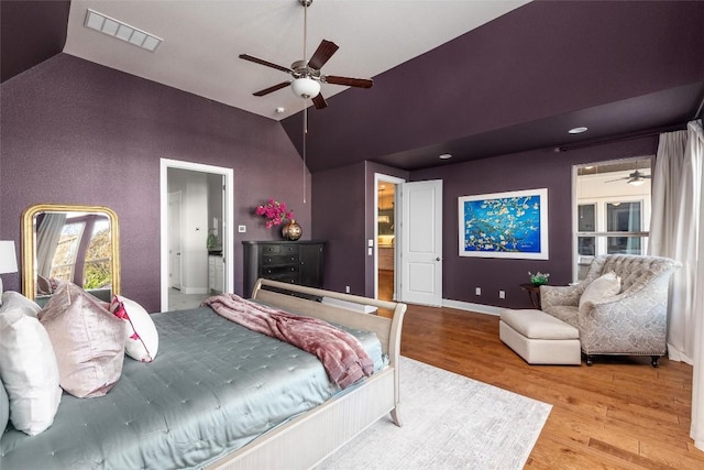 bedroom with baseboards, visible vents, vaulted ceiling, and wood finished floors