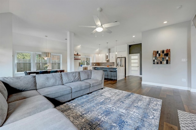 living area with lofted ceiling, ceiling fan, recessed lighting, dark wood-type flooring, and baseboards