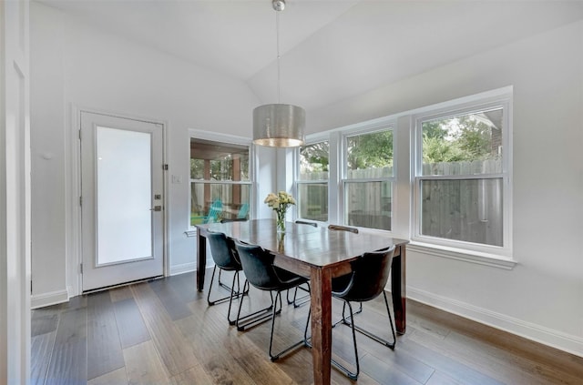 dining area featuring vaulted ceiling, baseboards, and wood finished floors