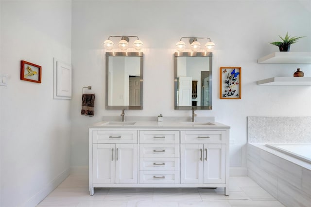 bathroom with double vanity, a relaxing tiled tub, baseboards, and a sink