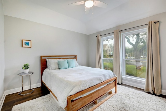 bedroom featuring lofted ceiling, dark wood finished floors, a ceiling fan, and baseboards