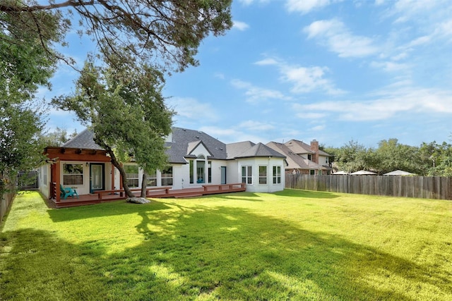 back of property featuring a deck, a yard, and a fenced backyard