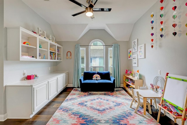 rec room with ceiling fan, vaulted ceiling, and dark wood-style flooring