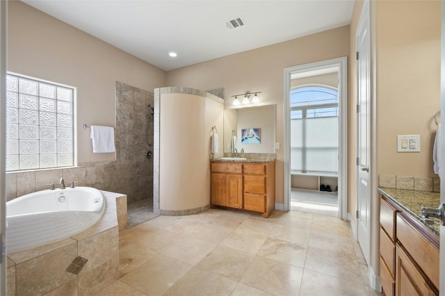 full bath featuring visible vents, baseboards, vanity, a walk in shower, and a bath