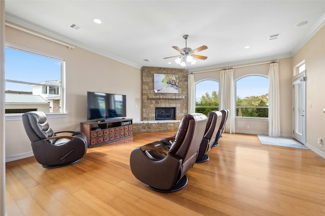 living room featuring light wood finished floors, ornamental molding, a fireplace, and baseboards