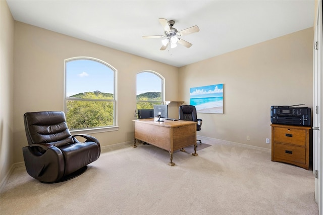 office area with light carpet, baseboards, and a ceiling fan