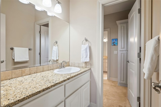 bathroom featuring tile patterned flooring, vanity, and baseboards