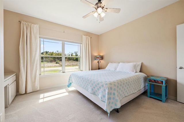 bedroom with light carpet, baseboards, and a ceiling fan