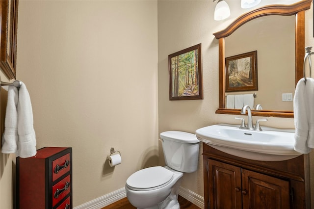 bathroom with vanity, toilet, and baseboards