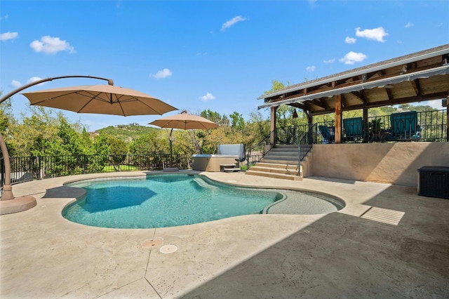 view of swimming pool with a patio, fence, a fenced in pool, and a hot tub