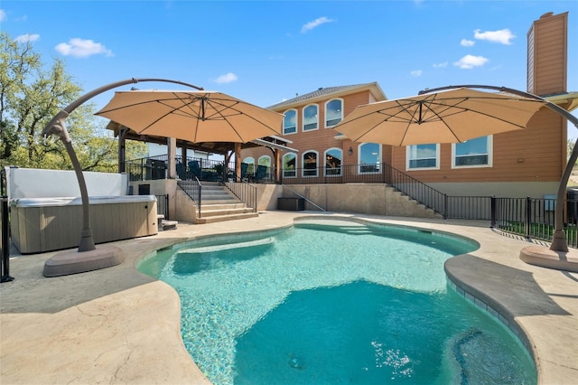 view of pool with stairs, a patio, fence, and a hot tub