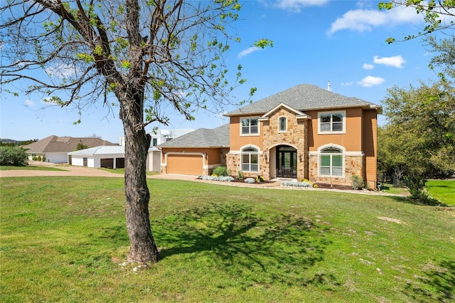 view of front of property featuring a front yard, stone siding, an attached garage, and stucco siding