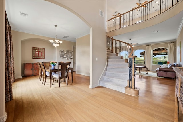 dining room with stairs, light wood-type flooring, visible vents, and crown molding