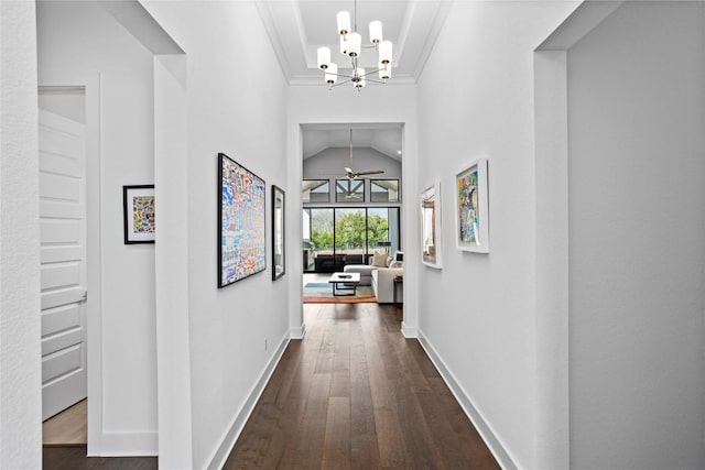 hallway with crown molding, dark wood-type flooring, an inviting chandelier, and baseboards