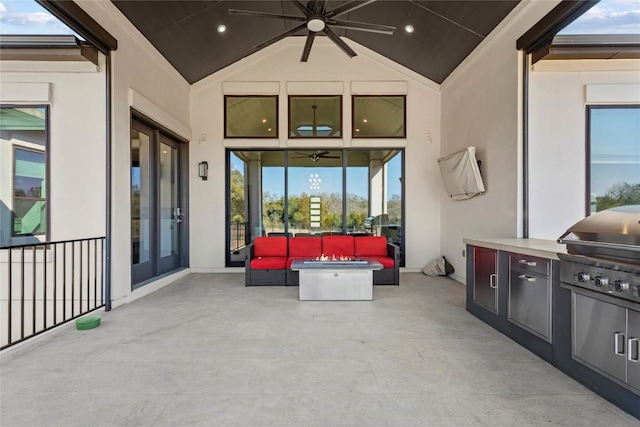 view of patio / terrace featuring area for grilling, ceiling fan, an outdoor living space, and an outdoor kitchen