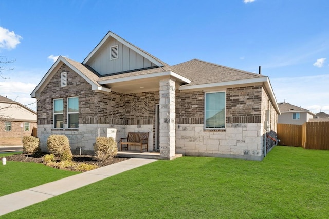 view of front of house with a front lawn, board and batten siding, fence, and brick siding