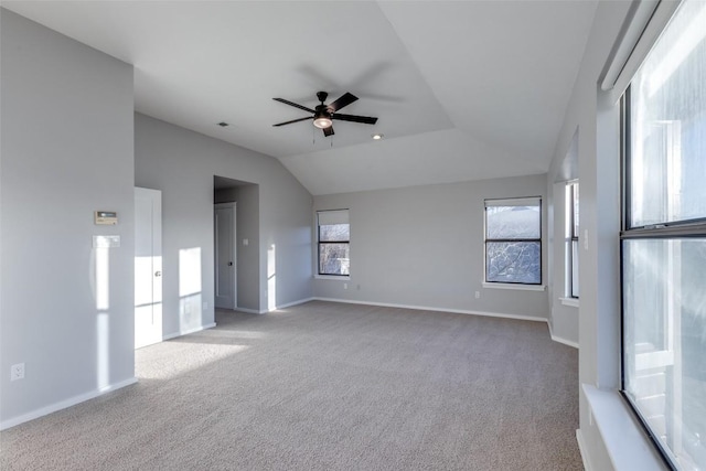 spare room with light carpet, ceiling fan, vaulted ceiling, and baseboards