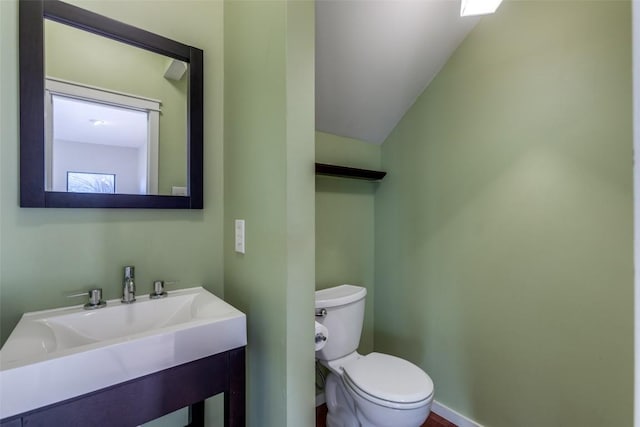 bathroom with toilet, baseboards, and a sink