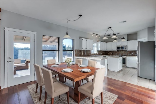 dining room with a wealth of natural light, visible vents, and light wood-style flooring