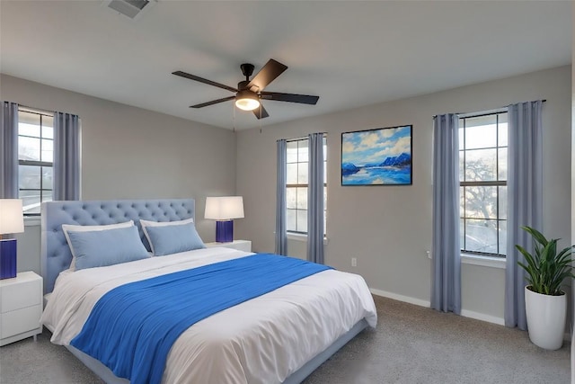 carpeted bedroom with multiple windows, baseboards, and visible vents