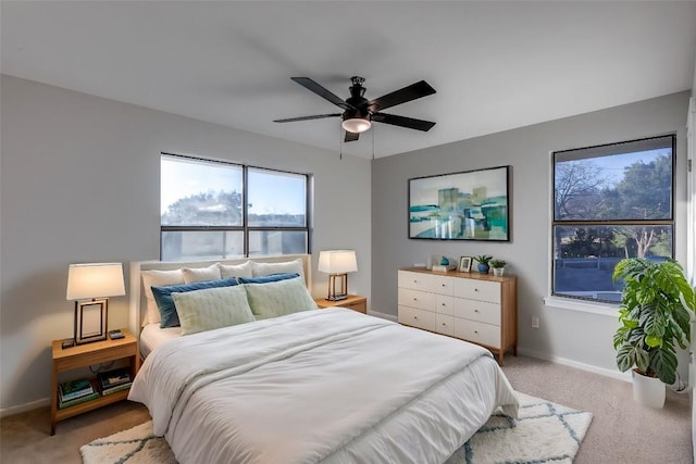 bedroom featuring a ceiling fan, light colored carpet, and baseboards