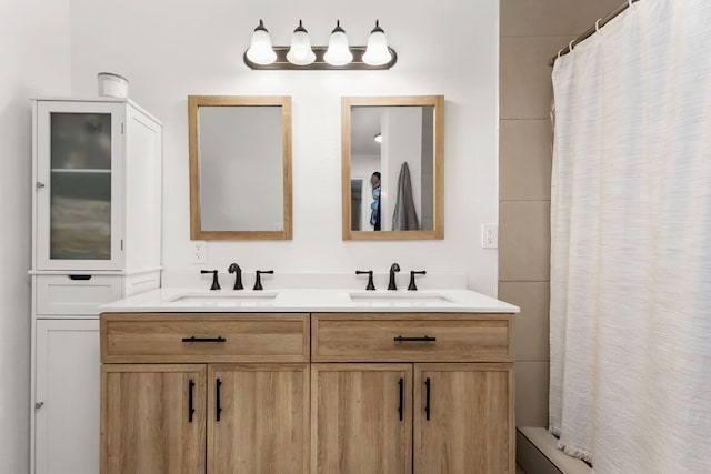 full bath featuring double vanity, a shower with curtain, and a sink