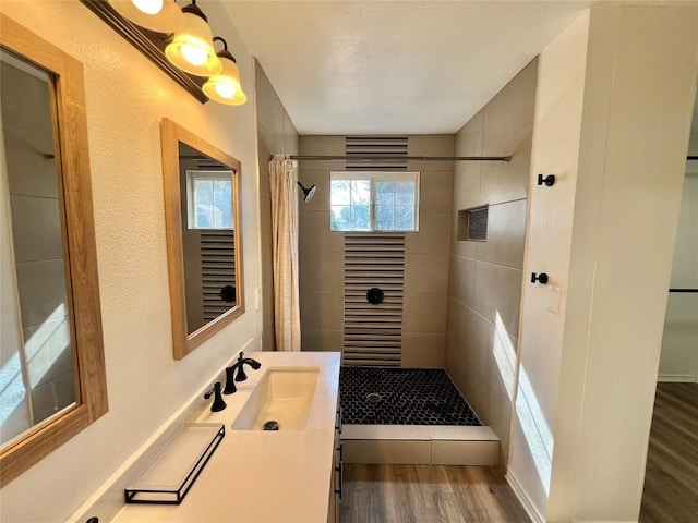 bathroom featuring a stall shower, wood finished floors, and vanity