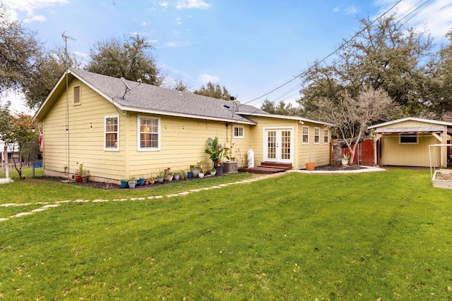 back of property featuring roof with shingles, fence, a lawn, and french doors