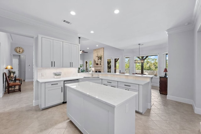 kitchen featuring a center island, light countertops, a sink, dishwasher, and a peninsula