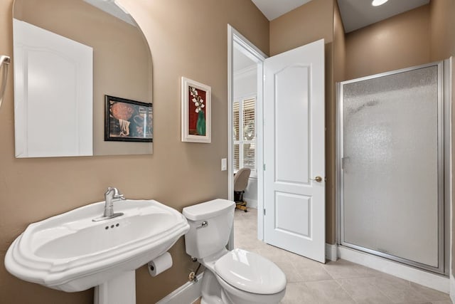 bathroom with a sink, a shower stall, toilet, and tile patterned floors