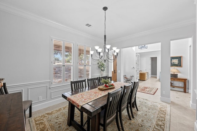 dining space featuring light tile patterned floors, ornamental molding, visible vents, and a decorative wall