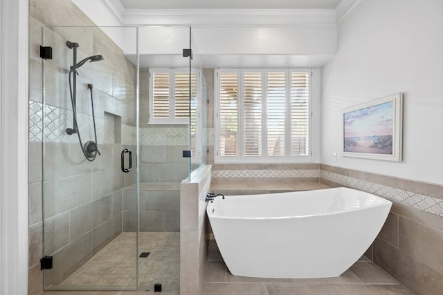 bathroom featuring a healthy amount of sunlight, a freestanding bath, crown molding, and a shower stall