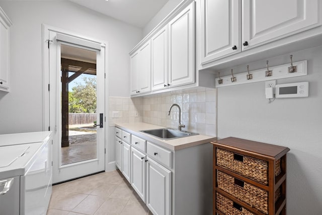 laundry room with independent washer and dryer, cabinet space, a sink, and light tile patterned floors