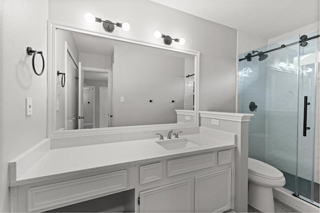 bathroom featuring vanity, toilet, and a stall shower
