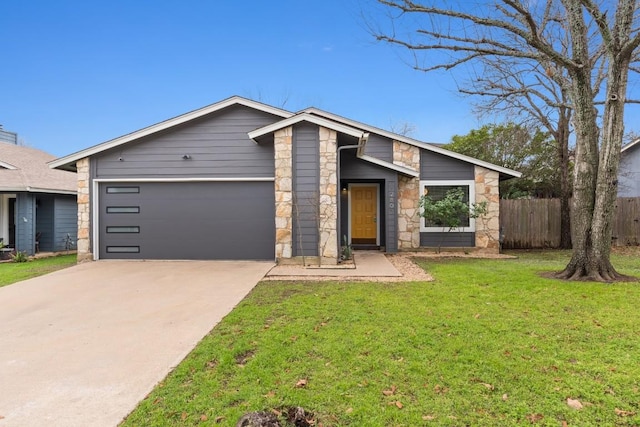 mid-century inspired home featuring a garage, stone siding, a front yard, and fence