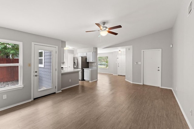 12807 Covington Trl, Austin, TX 78727 - unfurnished living room featuring a ceiling fan, lofted ceiling, wood finished floors, and baseboards
