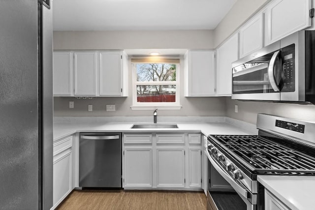 12807 Covington Trl, Austin, TX 78727 - kitchen with stainless steel appliances, a sink, white cabinets, and light countertops