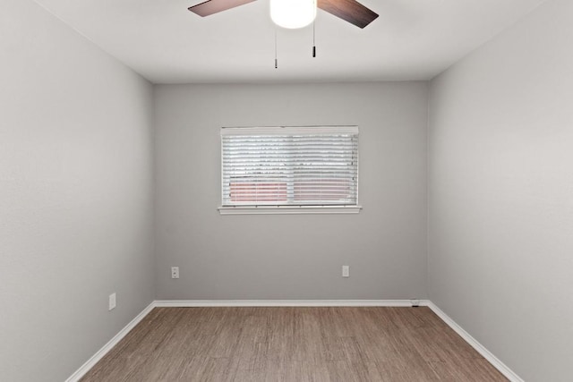 empty room featuring a ceiling fan, baseboards, and wood finished floors