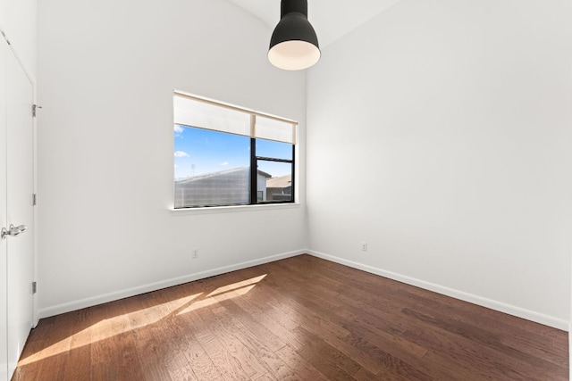 empty room with dark wood finished floors and baseboards