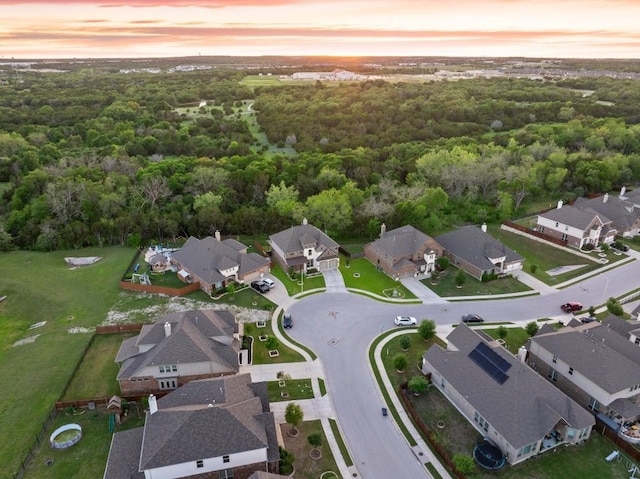 aerial view at dusk with a forest view and a residential view